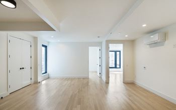 an empty living room with white walls and wood floors